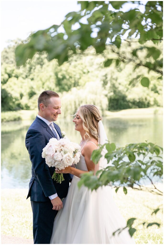 couple standing close together just after first look moment by pond at ironspire complex in adamstown pennsylvania