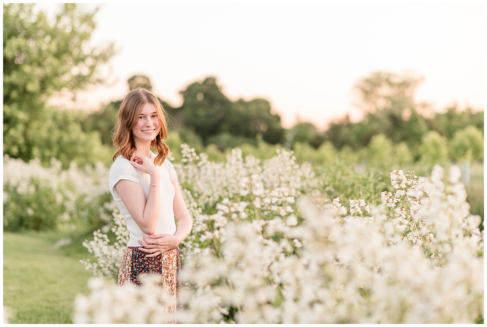 class of 2024 senior girl standing among white wildflowers at overlook park
