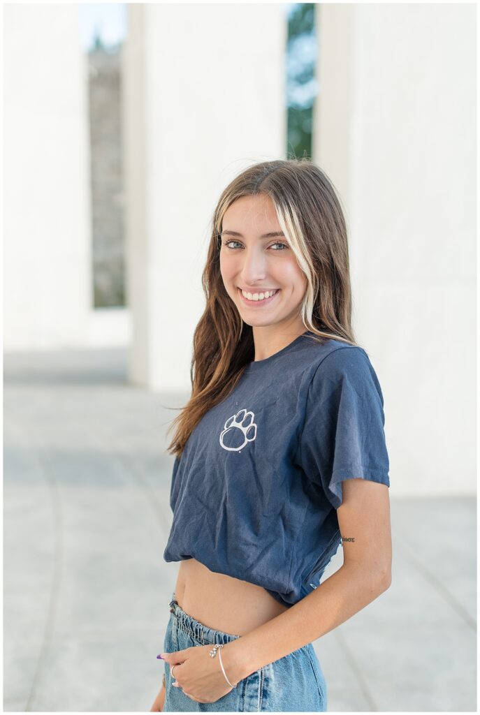 senior girl with her left shoulder towards camera and hand on her hip sporting her college crop top in hershey pennsylvania