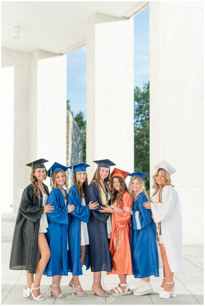 senior girls all huddled together wearing their caps and gowns at founder's hall in hershey pa