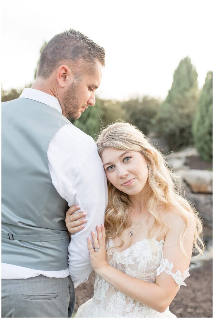 groom's back to camera as he looks down at bride holding his right arm and smiling at camera at folino estate