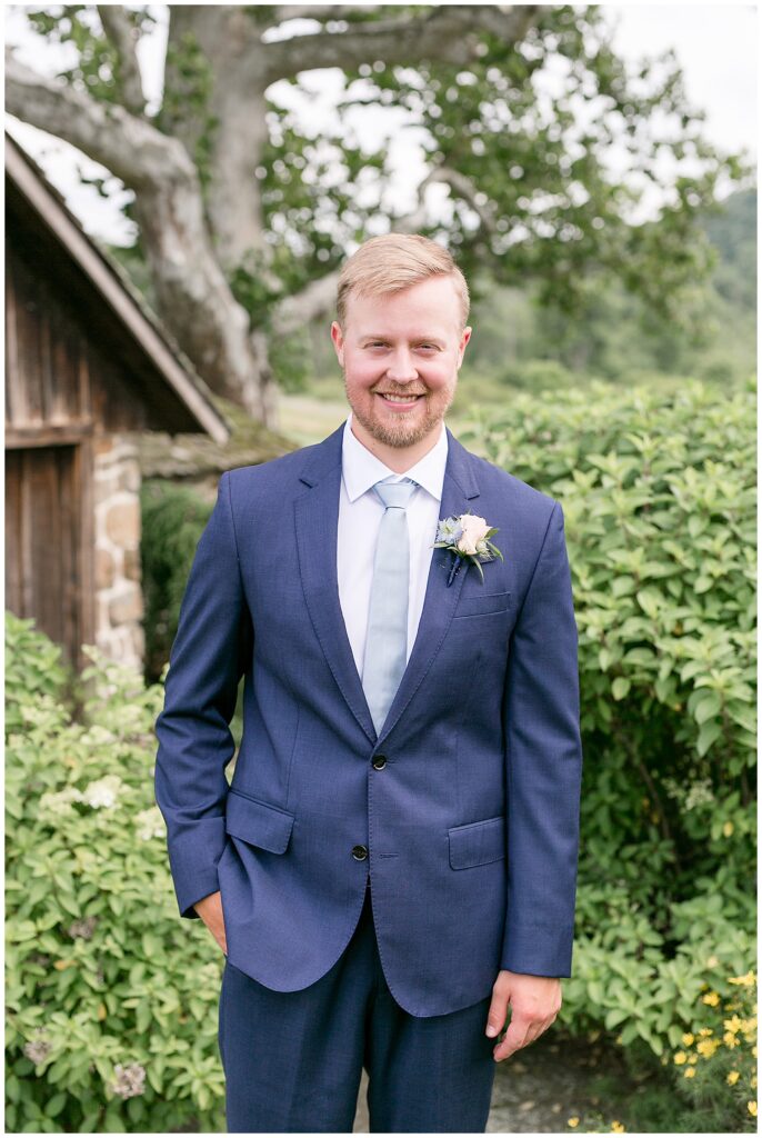 groom smiling at camera walking with one hand in pocket at French Creek Golf Club wedding