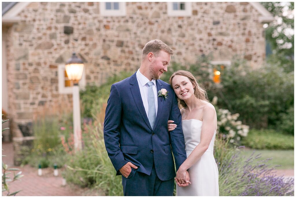 bride rests head on groom's shoulder and smiles to camera while he smiles down to her