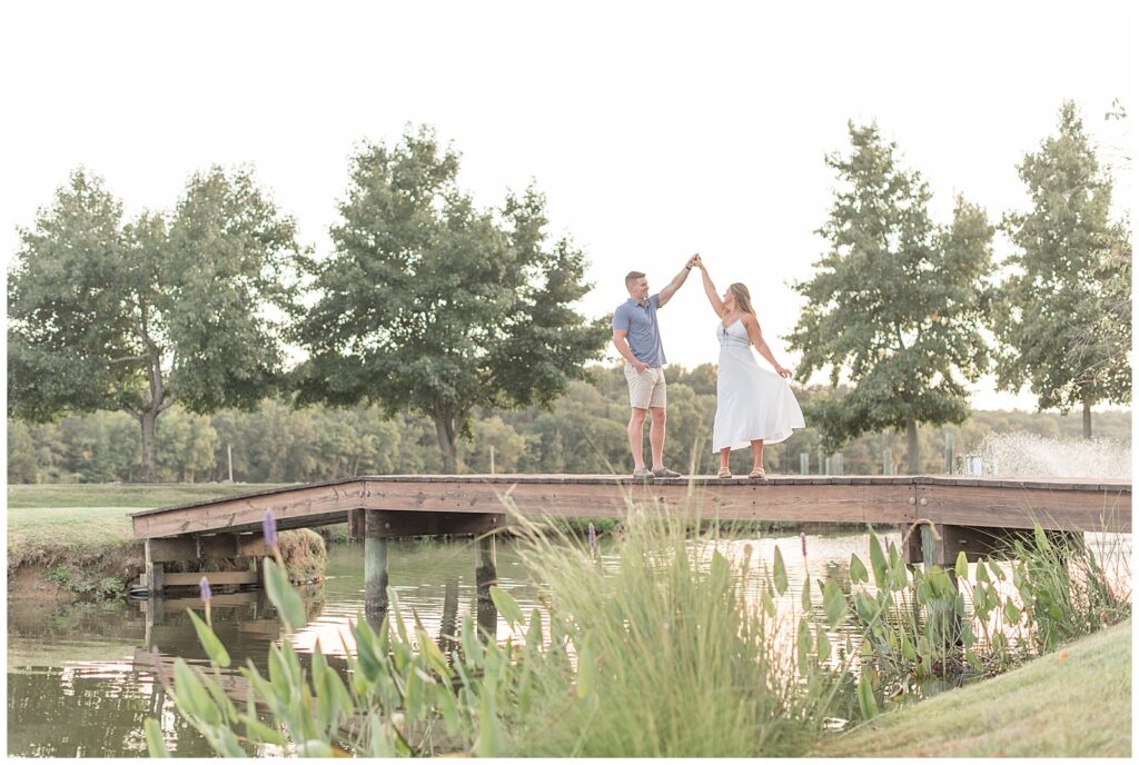 guy twirling girl on bridge at sunset at farm in maryland