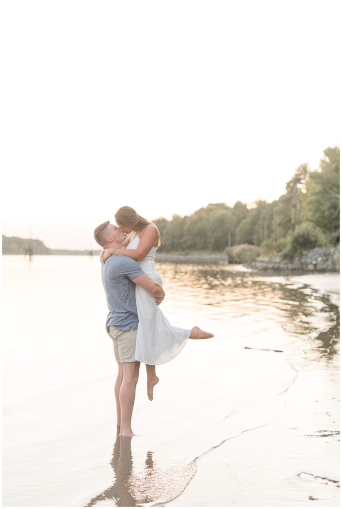 guy lifting girl as they kiss along beach in chesapeake city maryland