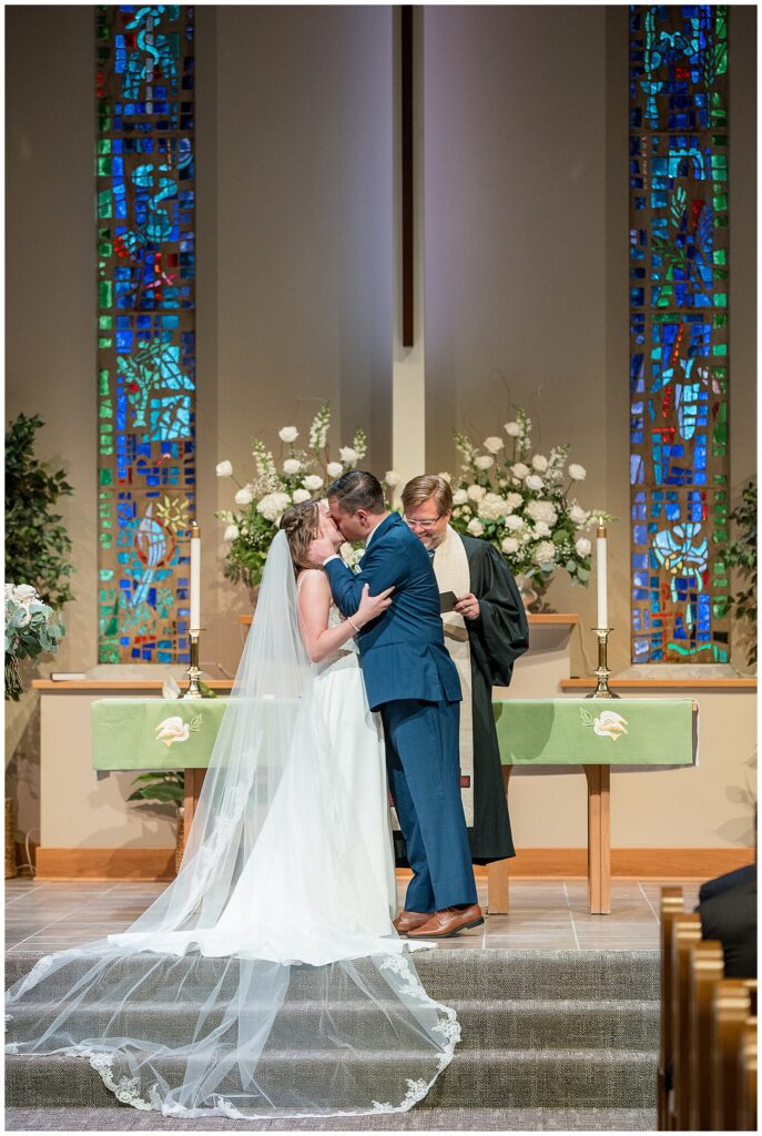 couple sharing their first kiss in church wedding ceremony in pennsylvania