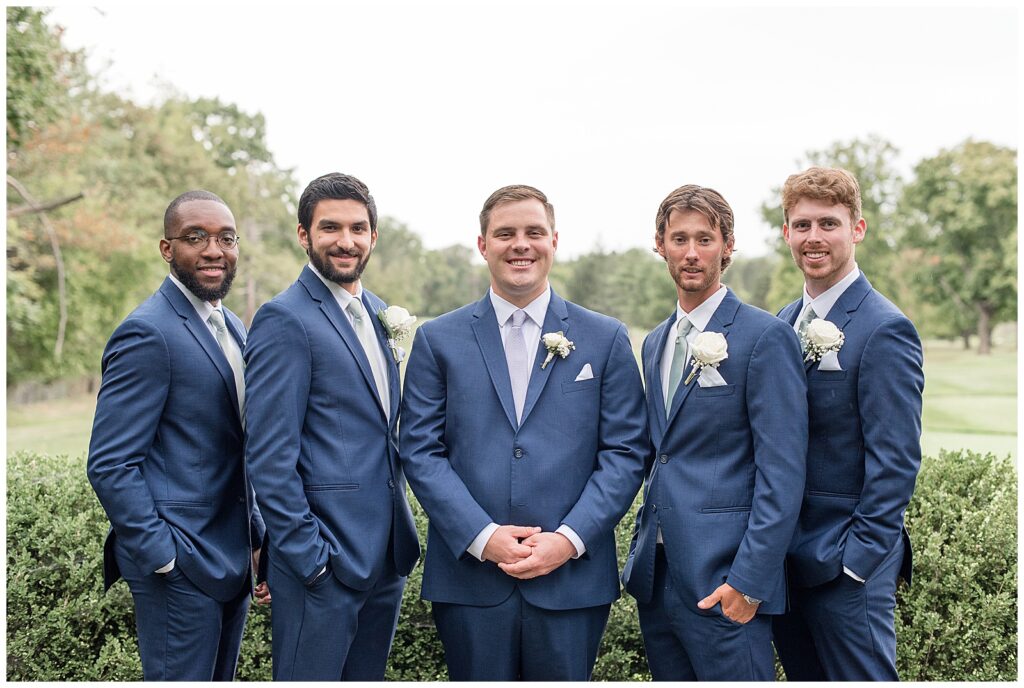 groom with his four groomsmen in navy blue suits in flourtown pennsylvania