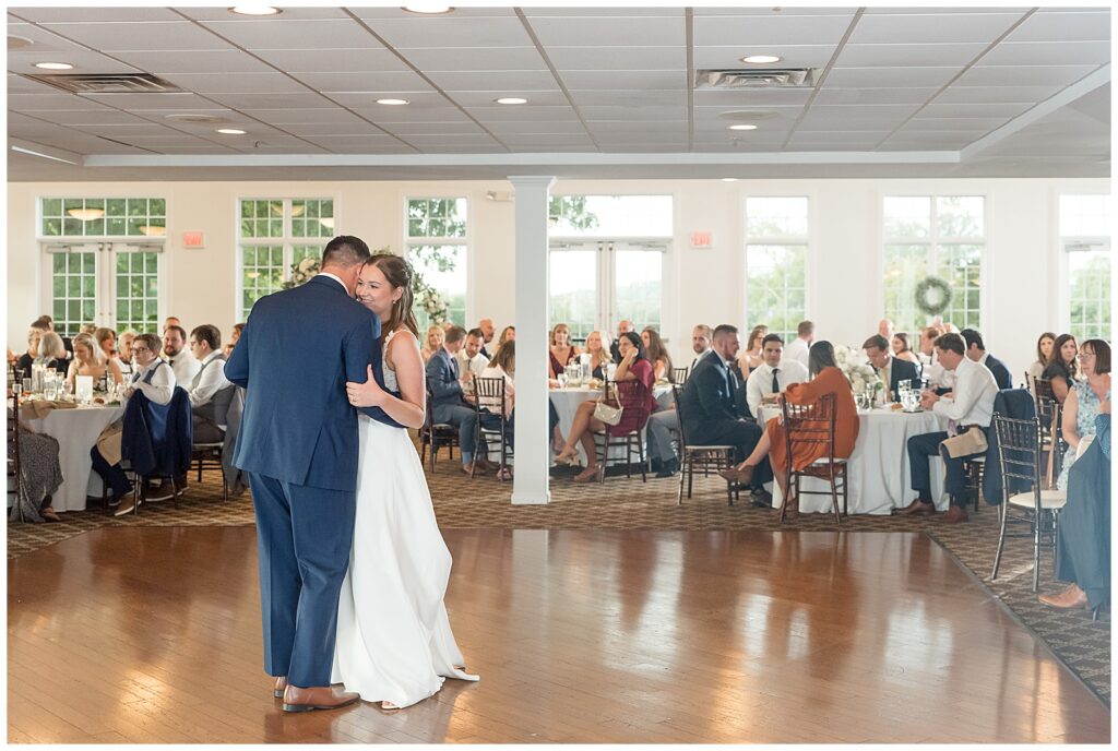 couple sharing their first dance as guests watch at indoor reception at flourtown country club