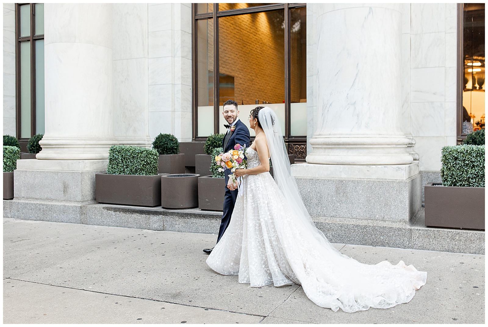 groom leading his bride along sidewalk outside cescaphe in philly