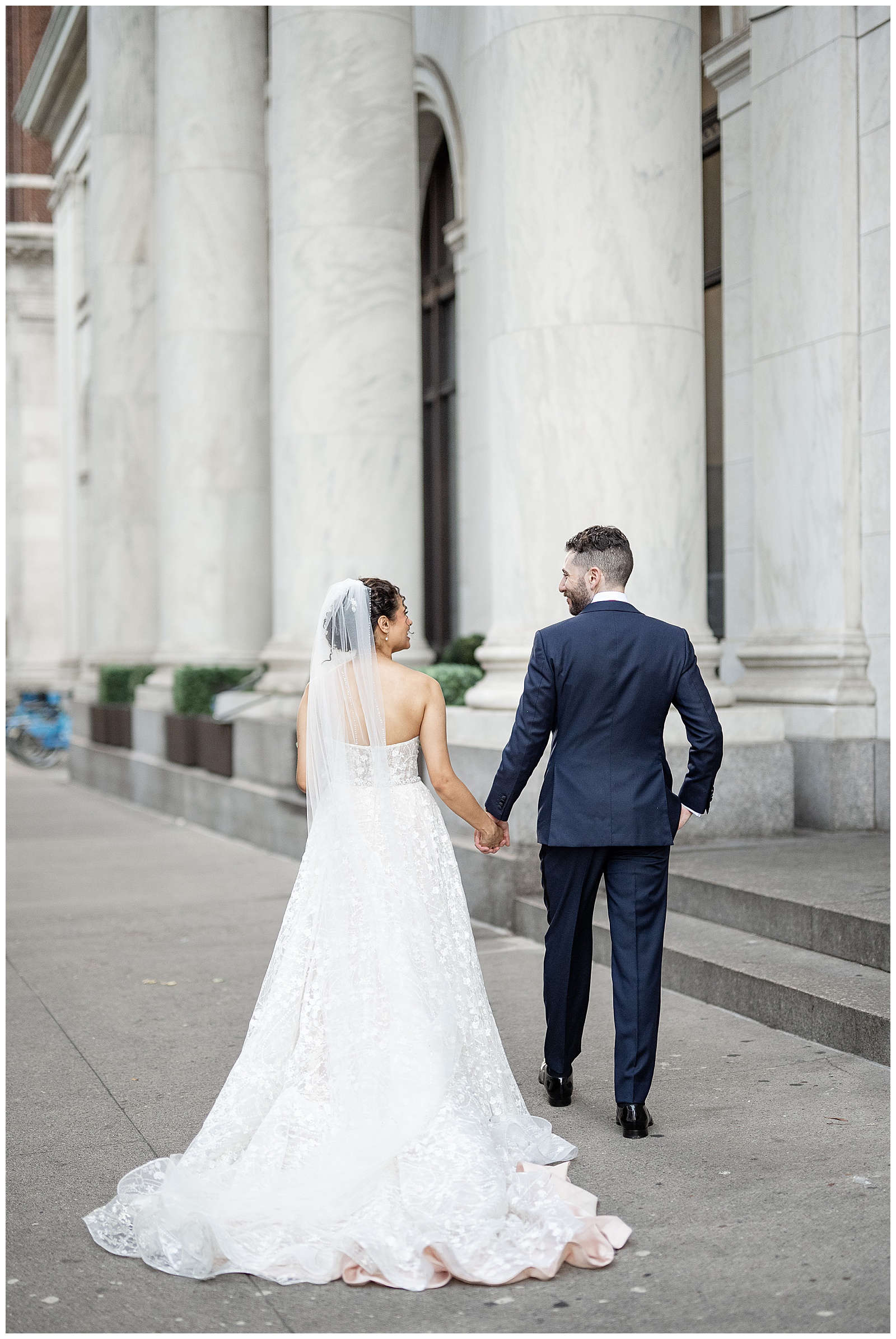 couple holding hands with their backs toward camera along sidewalk outside of cescaphe