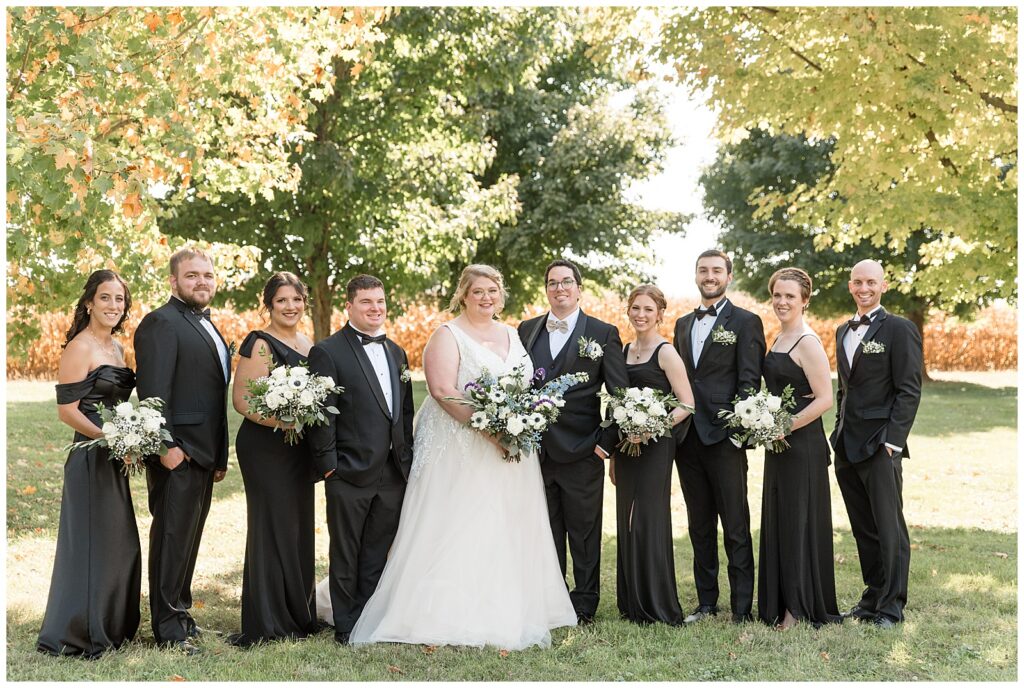 couple with their bridal party on sunny fall day at the barn at silverstone in lancaster pa