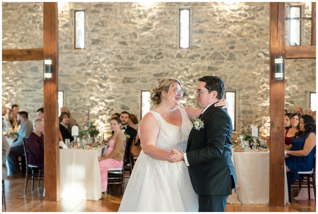 couple sharing their first dance inside barn reception at the barn at silverstone