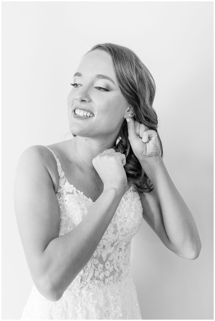 black and white photo of bride adjusting her left earring at the links at gettysburg