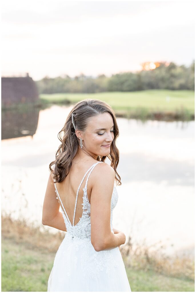 bride looking back over her right shoulder with her back towards the camera at sunset by pond in gettysburg pennsylvania