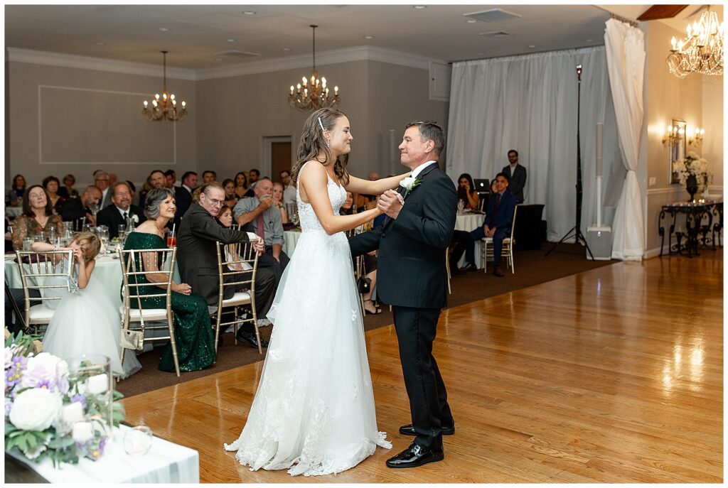 bride dancing with her father during indoor reception as guests watch at the links at gettysburg