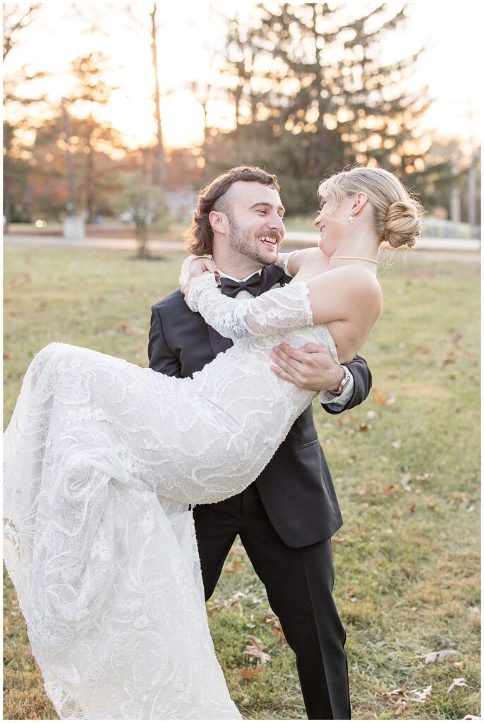 groom holding his bride as they smile at each other at annunciation greek orthodox church in york county