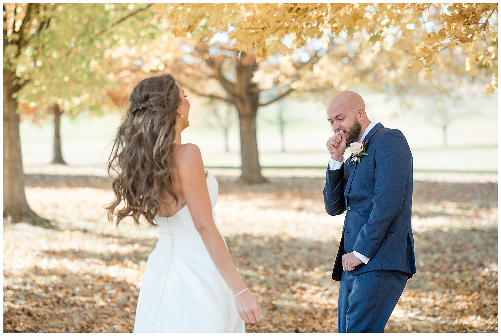 couple sharing their first look moment by colorful fall trees in lancaster county pennsylvania