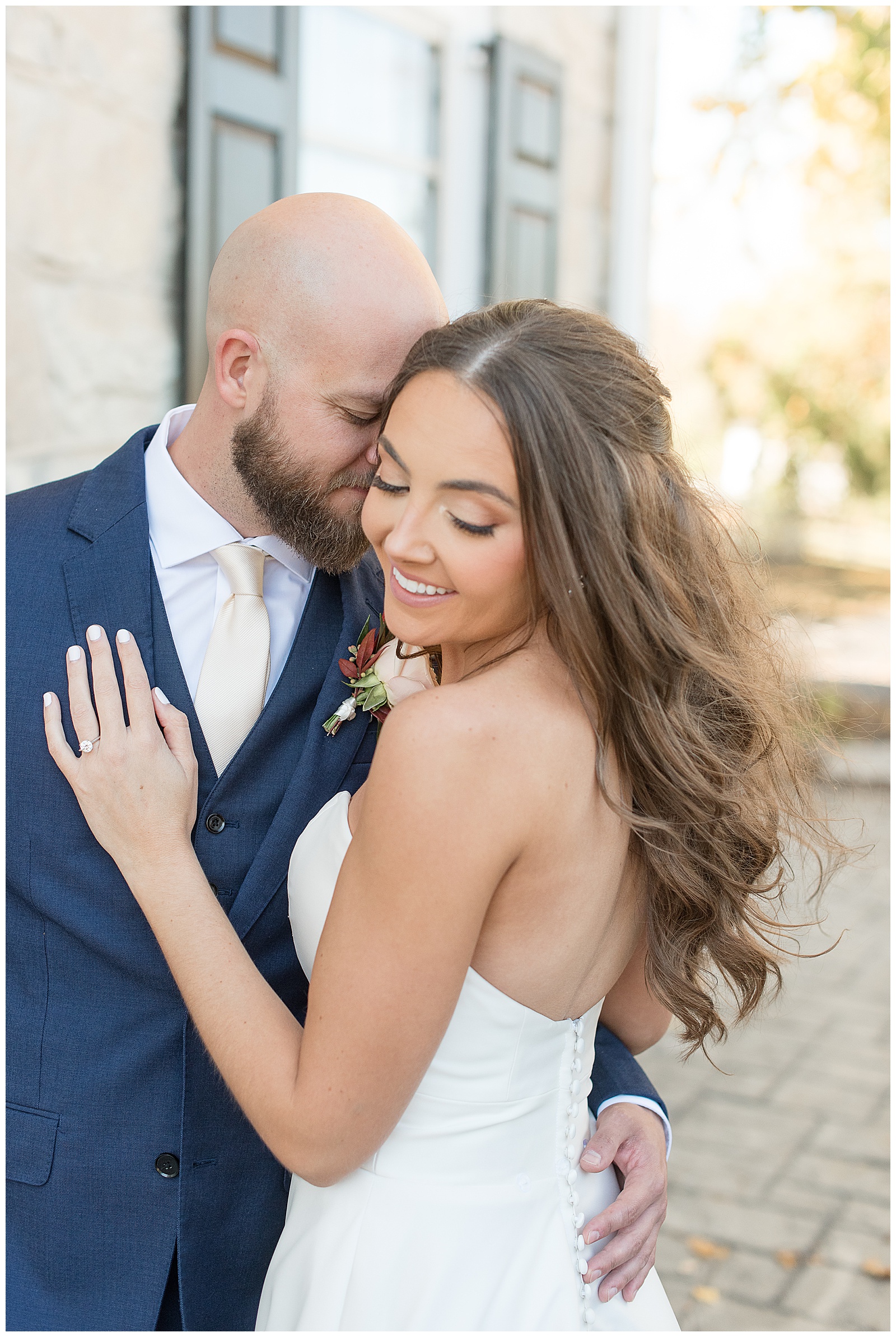 closeup photo of groom nuzzling into bride's right temple on sunny fall day at the barn at silverstone