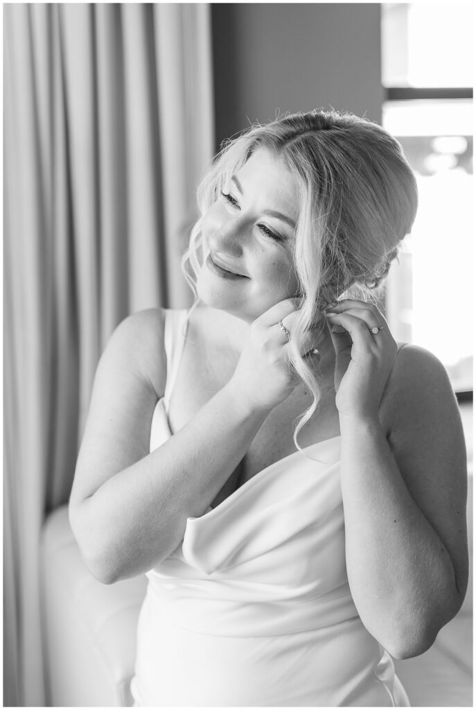 black and white photo of bride adjusting her left earring at hotel monaco in philadelphia