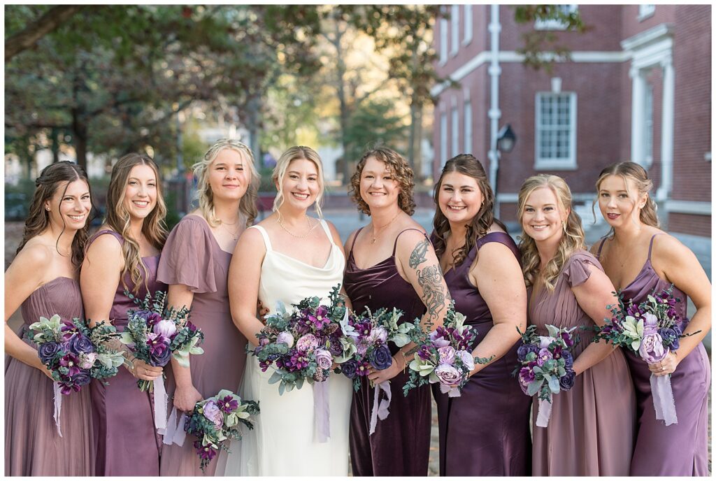 bride with her seven bridesmaids wearing shades of mauve gowns in philadelphia pennsylvania