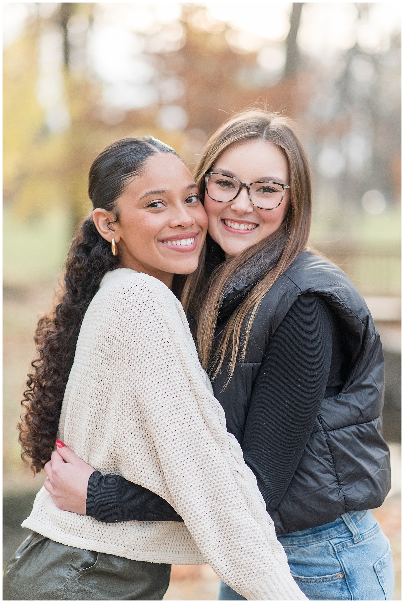 two senior girls hugging as they smile at camera at long's park in lancaster pennsylvania