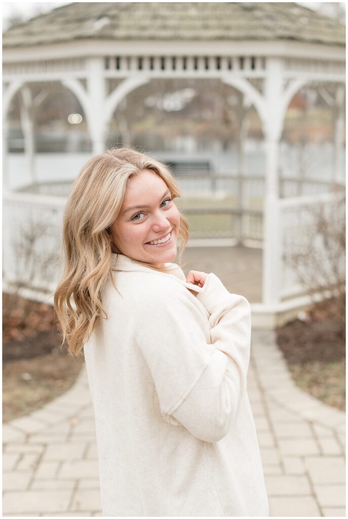 senior girl looking back over right shoulder with gazebo in background at longs park