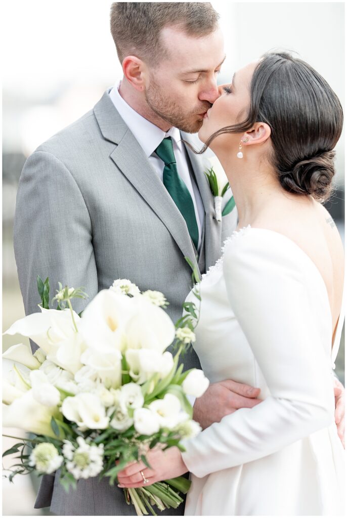 closeup photo of couple kissing as bride holds bouquet of white flowers in her left hand in adamstown pa