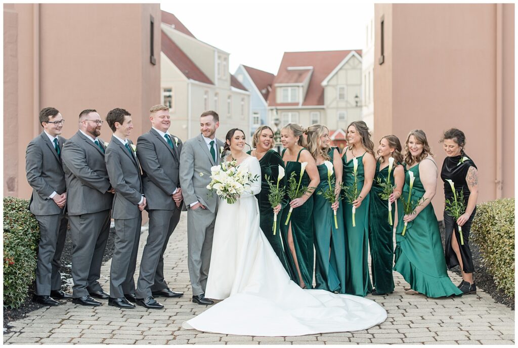 groom with his groomsmen wearing gray suits and bride with her bridesmaids wearing shades of dark green at stoudtburg village