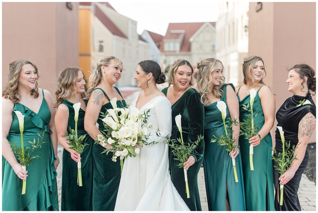 bride with her bridesmaids wearing dresses in different shades of dark green at stoudtburg village