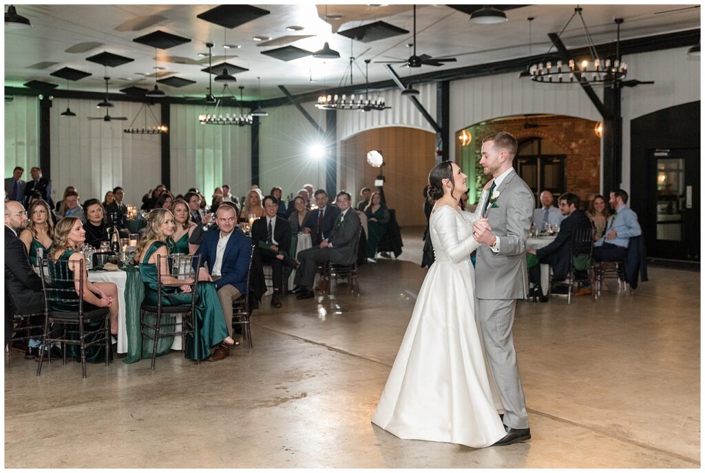 couple sharing their first dance at indoor reception as guests watch them at ironspire complex in adamstown pennsylvania