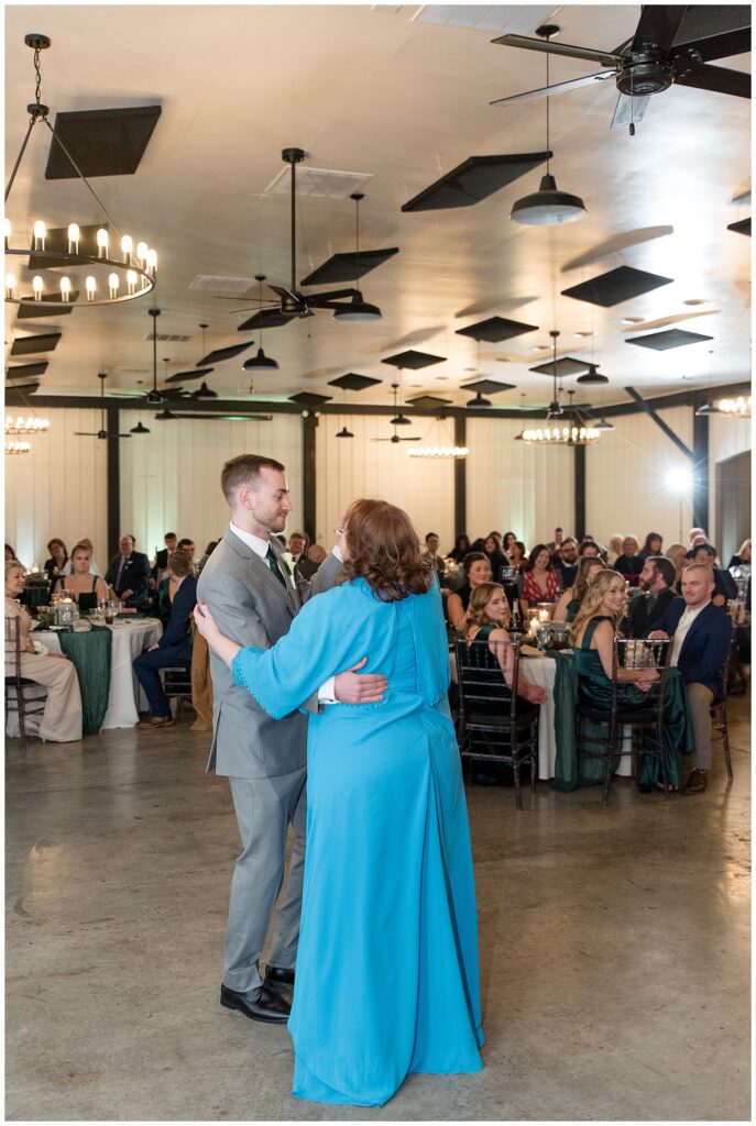 groom dancing with his mom at indoor reception as guest smile and watch at ironspire complex