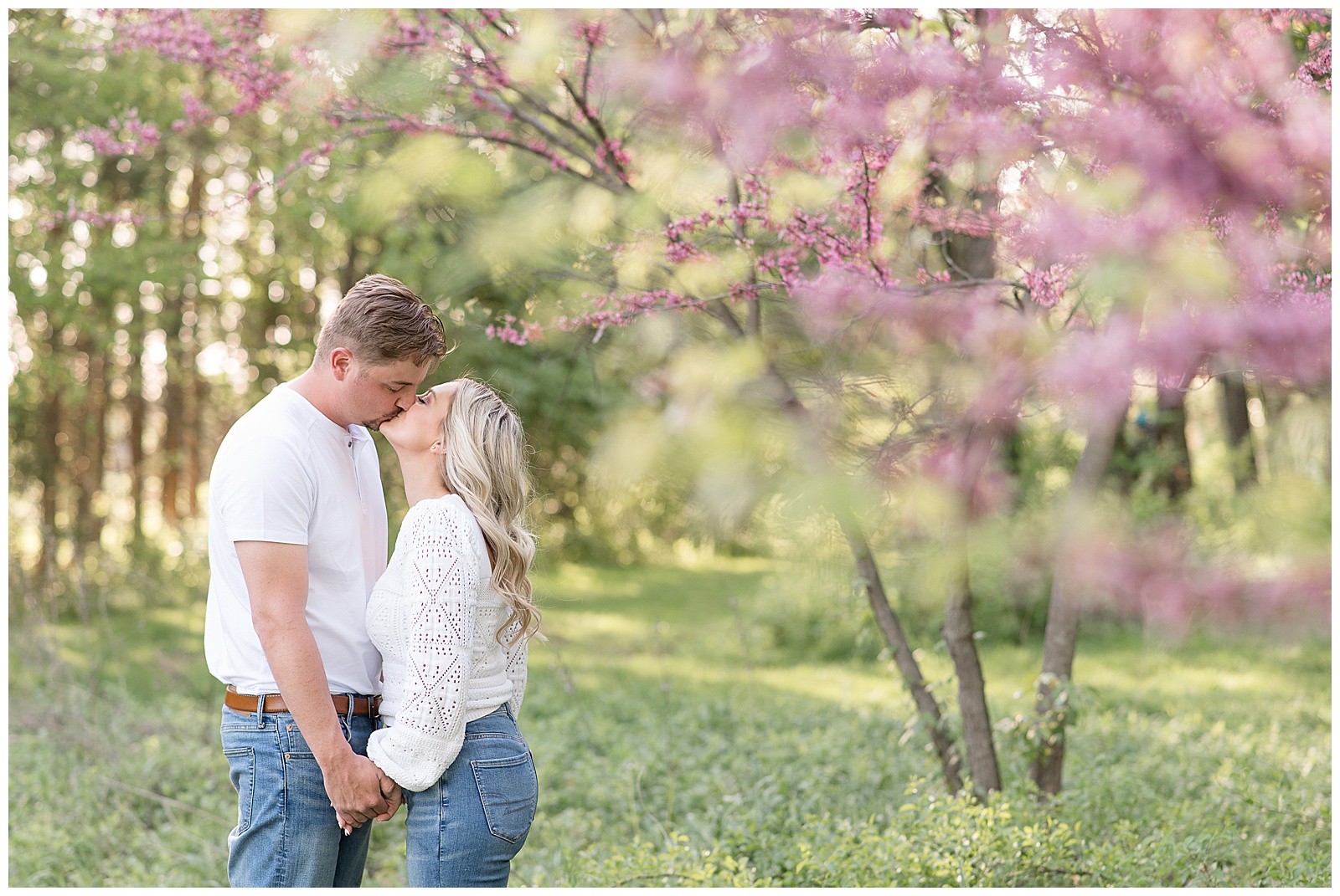 engaged couple kissing by blooming pink tree at overlook park in lancaster pennsylvania