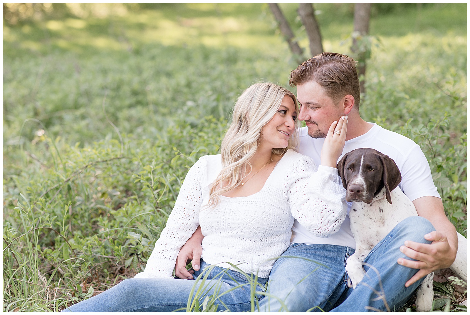 couple sitting in the grass with their dog at sunset at overlook park in lancaster county