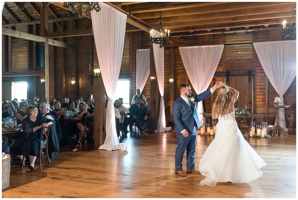 couple sharing their first dance inside barn reception at the star barn