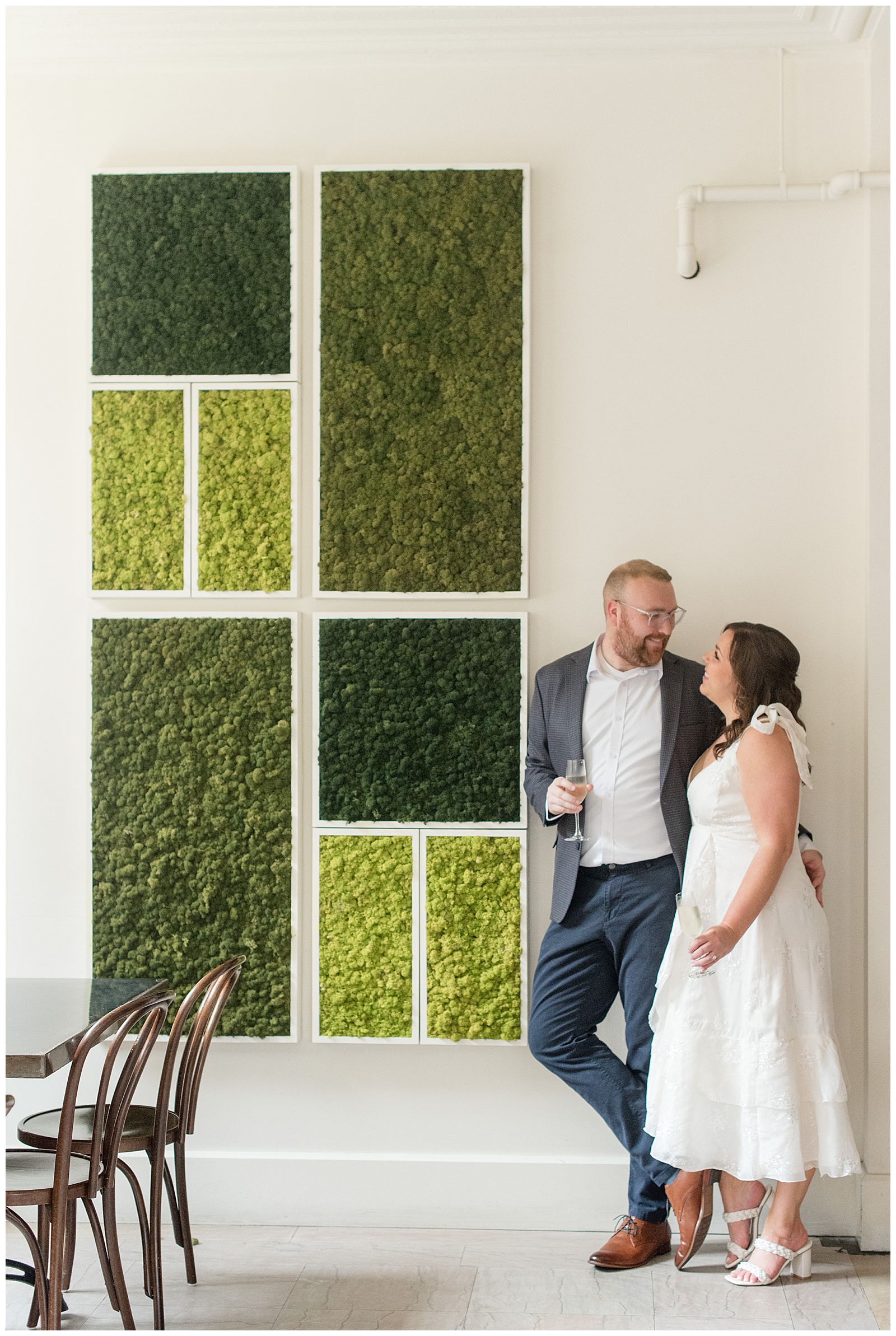 couple hugging by white wall with geometric plant design in lancaster city