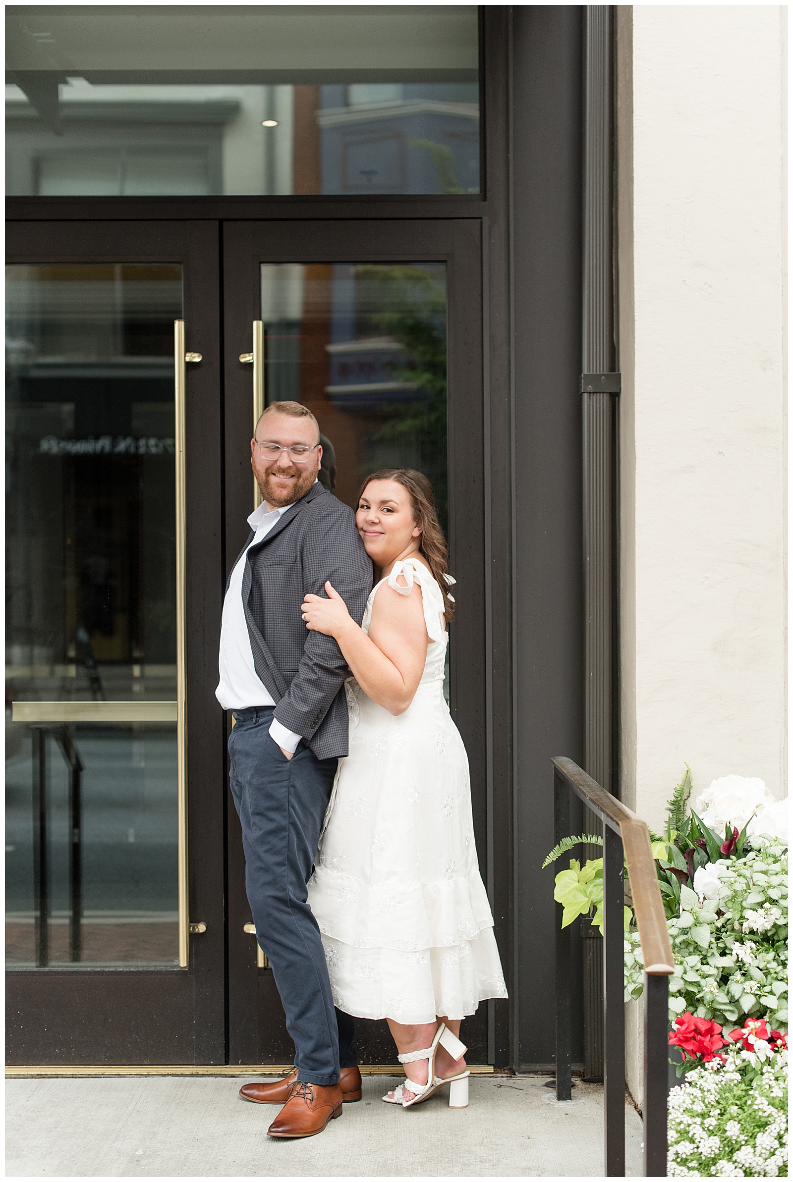 woman standing behind her man outside of restaurant with large black doors in lancaster city