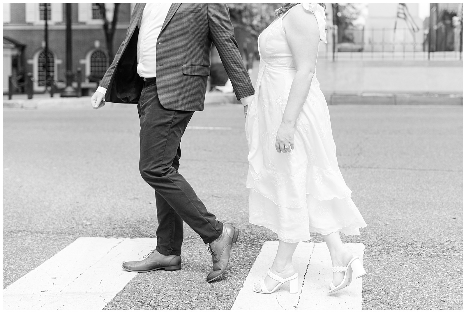 black and white photo of couple crossing the street at crosswalk with just their lower bodies shown in lancaster city
