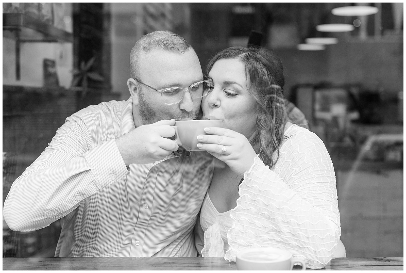 black and white photo of couple sipping on the same cup of coffee in lancaster pennsylvania