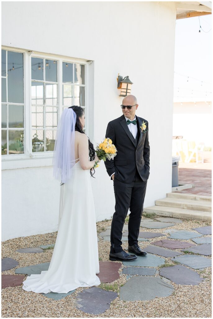 bride and groom share first loo moment outside white building at lauxmont farms in pennsylvania