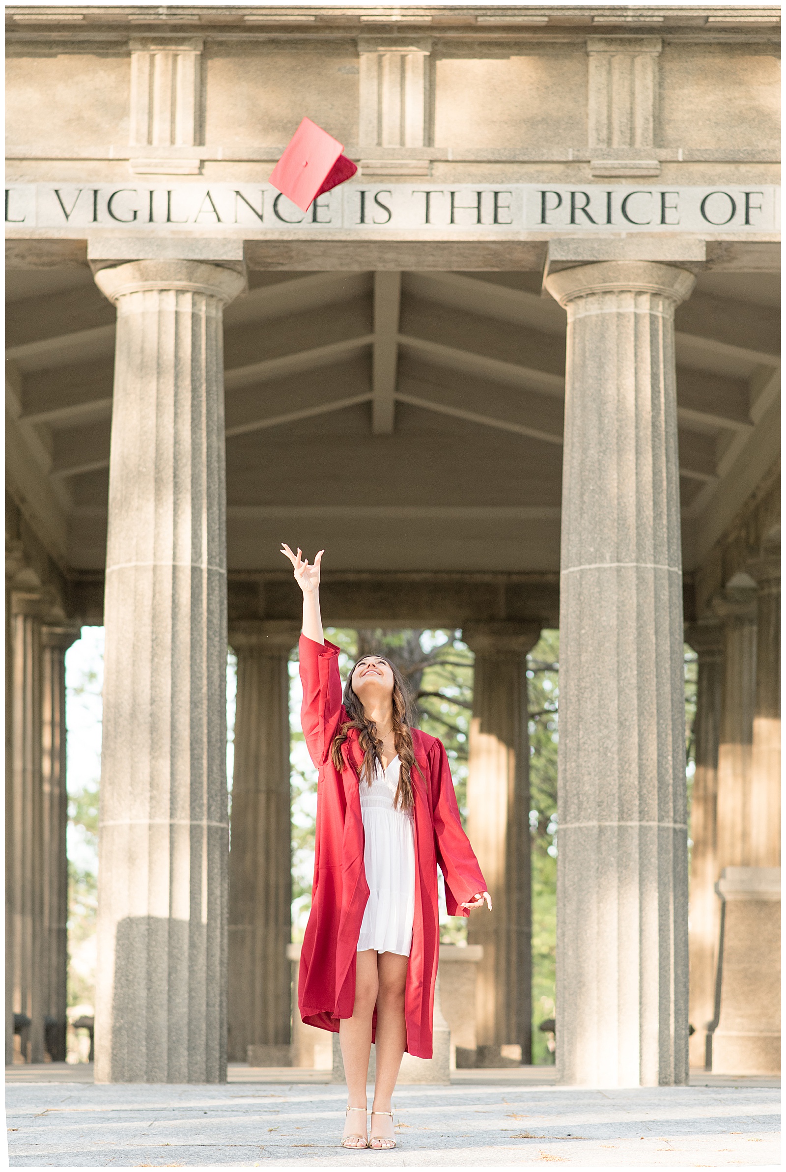 senior girl tossing her red graduation cap high into the air at masonic village in elizabethtown pa