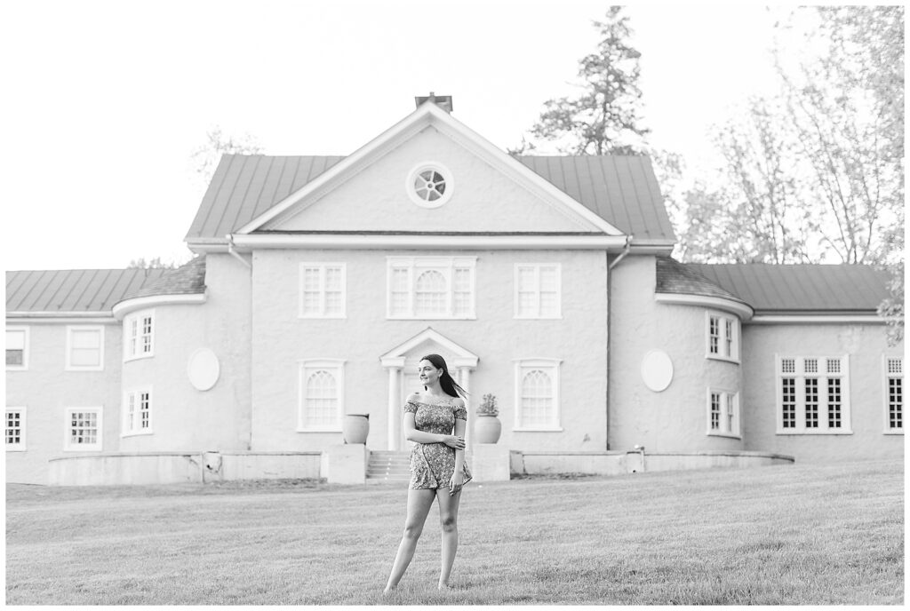 black and white photo of senior girl in front of large house at hibernia park in pennsylvania