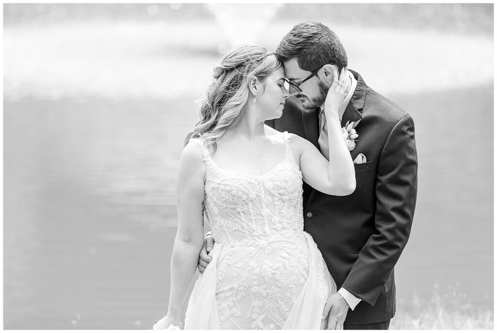 black and white photo of bride standing in front of groom with her left hand resting on his left cheek for this Bryn Awel Manor Summer Wedding
