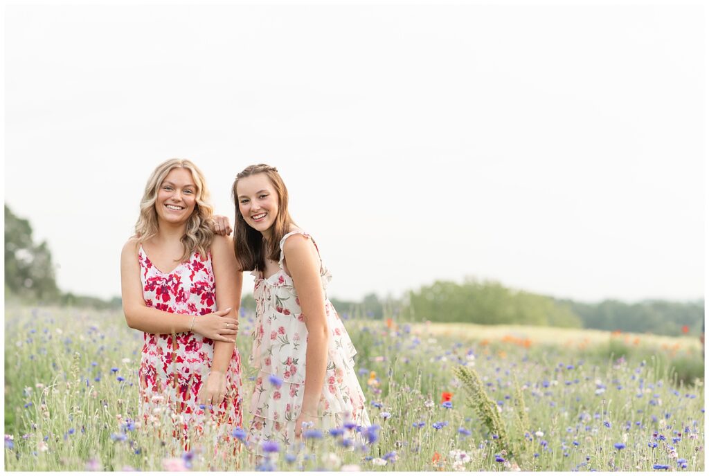 two senior girls in field of wildflowers on spring day for this Senior Wildflower Lookout Session