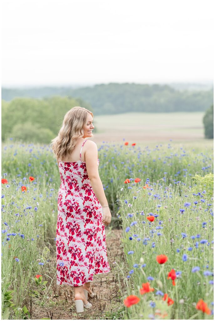 senior girl looking back over right shoulder with her back to the camera for this Senior Wildflower Lookout Session