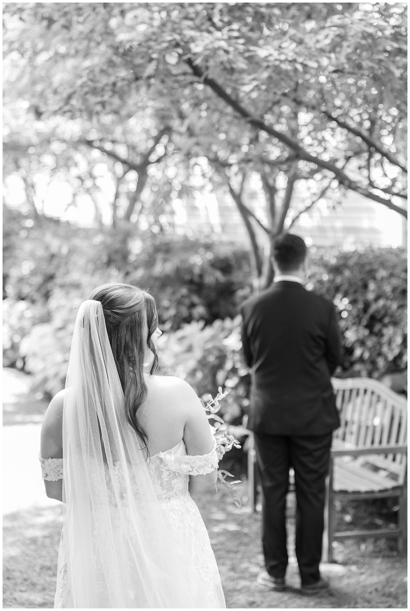 black and white photo of bride coming up behing her groom for the first look moment for this Inn at Leola Village Wedding