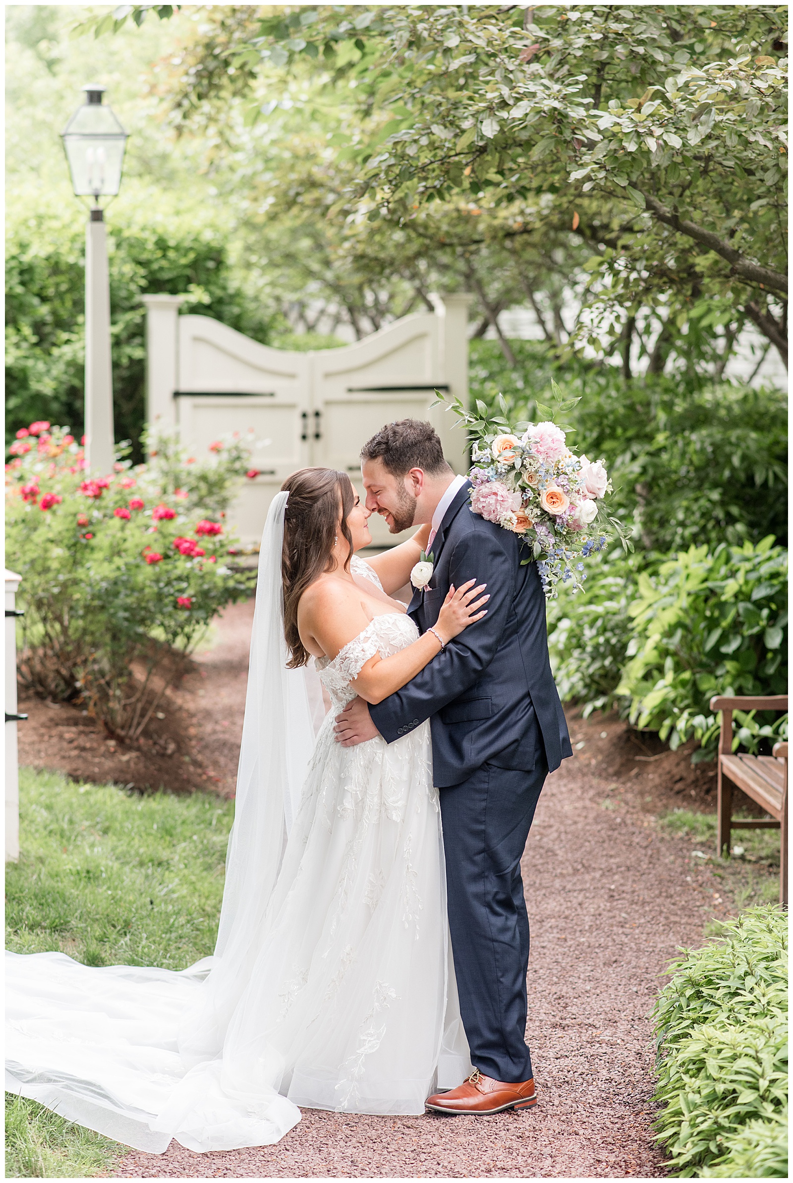couple almost kissing on their wedding day by beautifully landscaped garden at the Inn at Leola Village Wedding