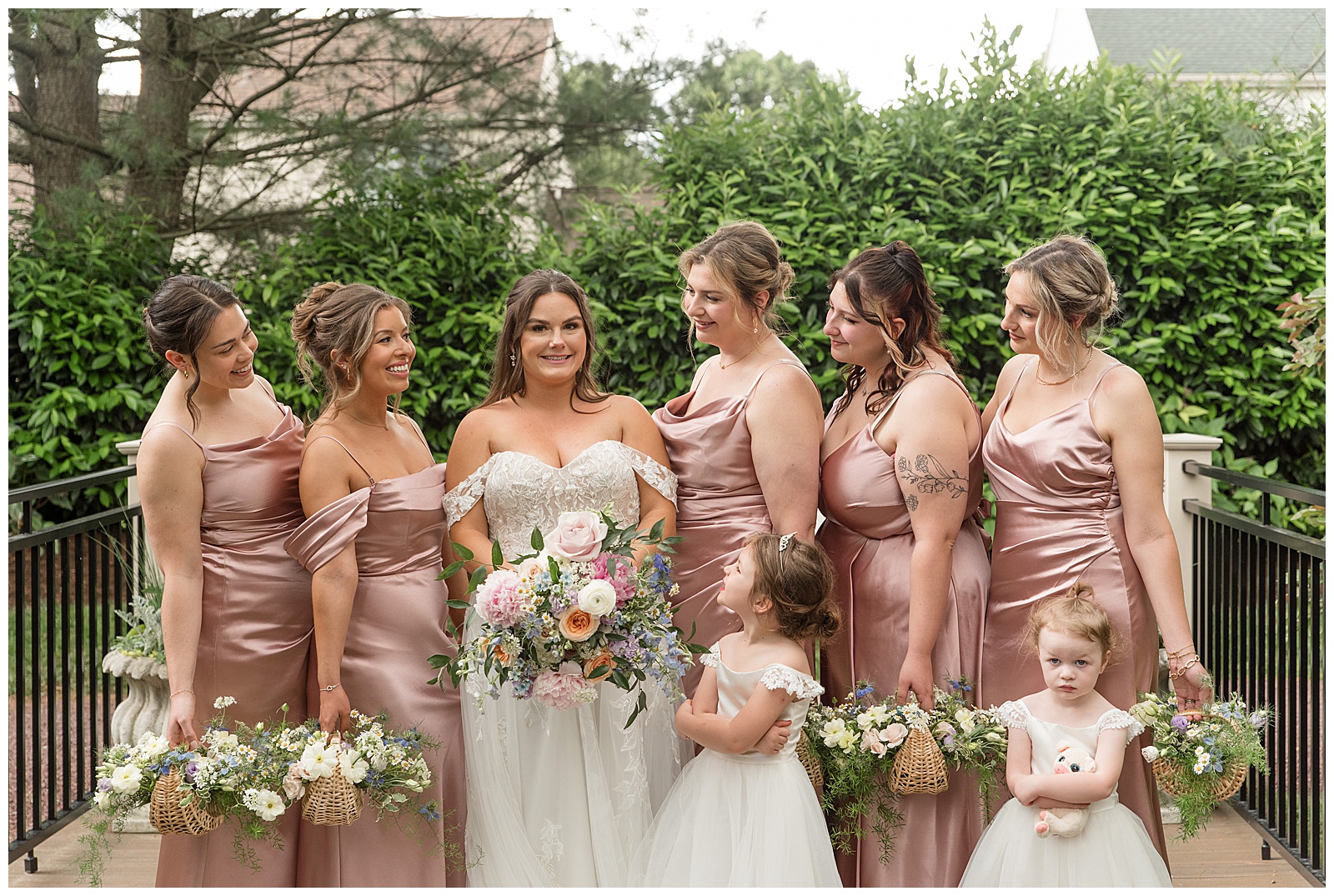 bride surrounded by her five bridesmaids wearing blush gowns and her two flowergirls in white gowns at this Inn at Leola Village Wedding