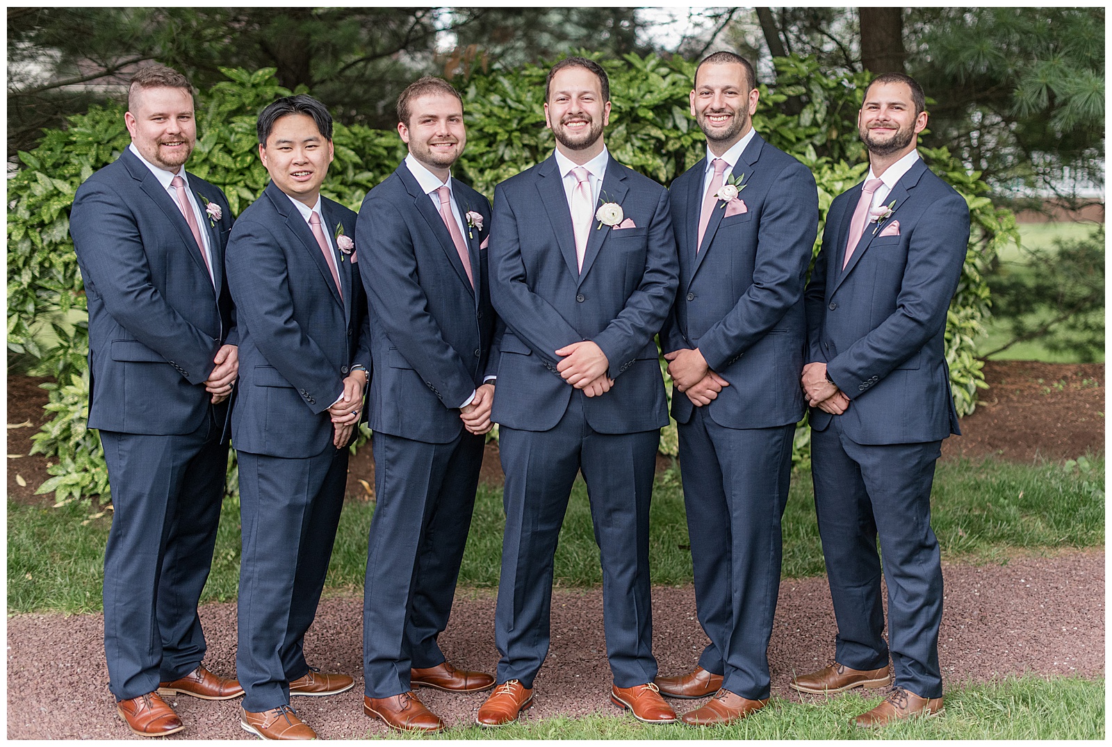 groom with his five groomsmen all wearing navy blue suits and light pink ties at this Inn at Leola Village Wedding