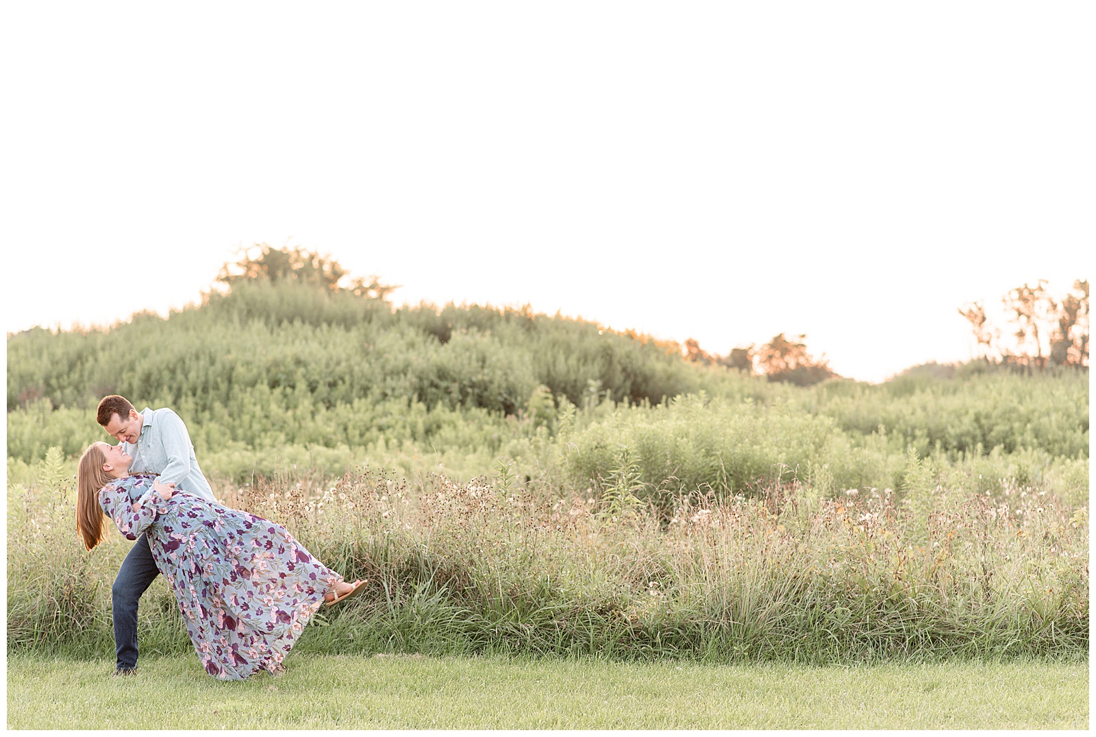 guy dips back his girl by field of wildflowers for this Puppy-Loving Overlook Park Engagement Session