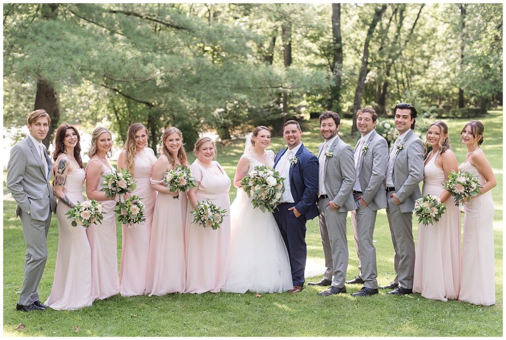 wedding party with light pink dresses and light gray suits